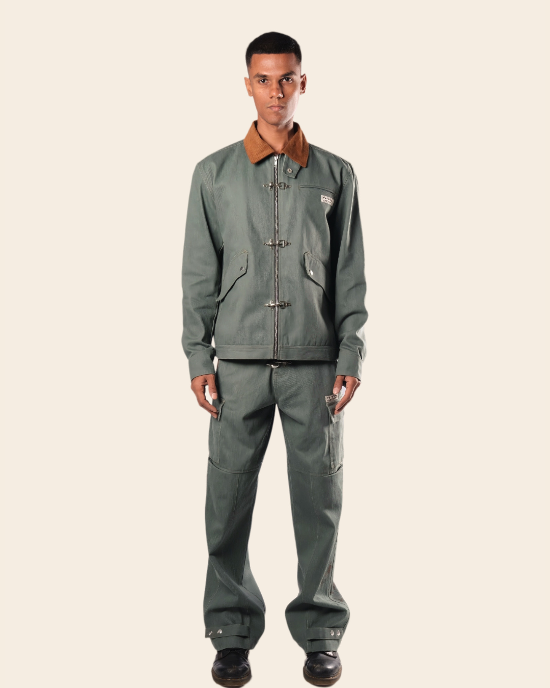 Man wearing a gray jacket and pants on a beige background