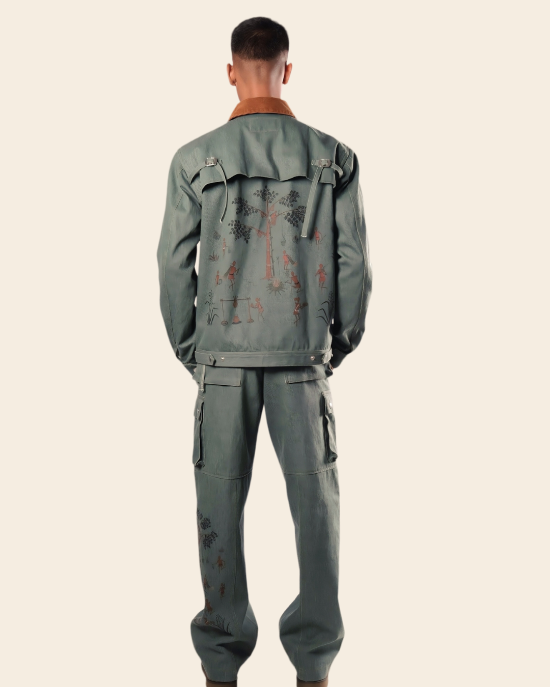 Person wearing a green distressed jacket and pants on a beige background