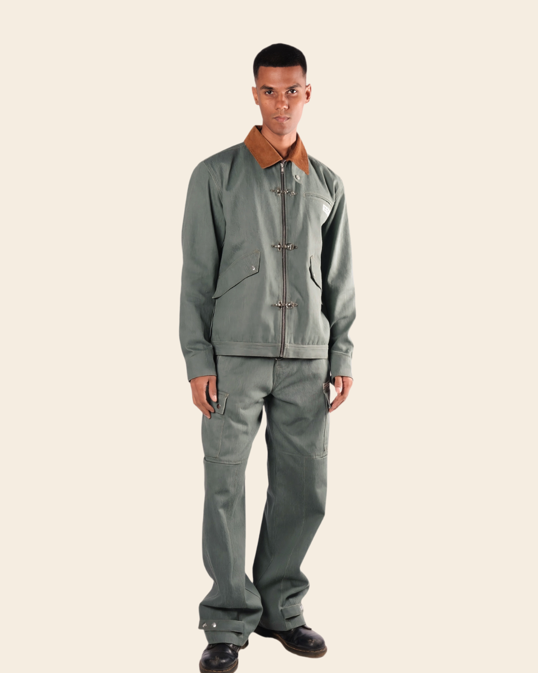 Man wearing a gray jacket and pants on a beige background