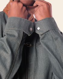 Close-up of a person wearing a green jacket with a buttoned collar.