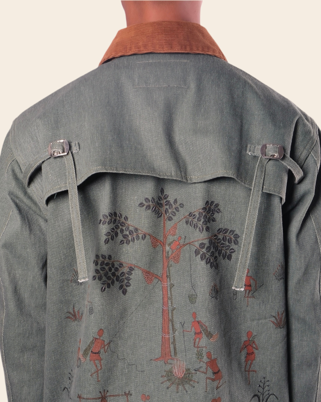 Green jacket with tree and figure design on a plain background